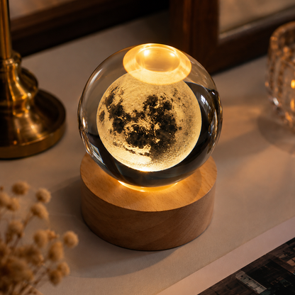 Decorative moon lamp on a wooden base with a warm glow, placed on a surface.