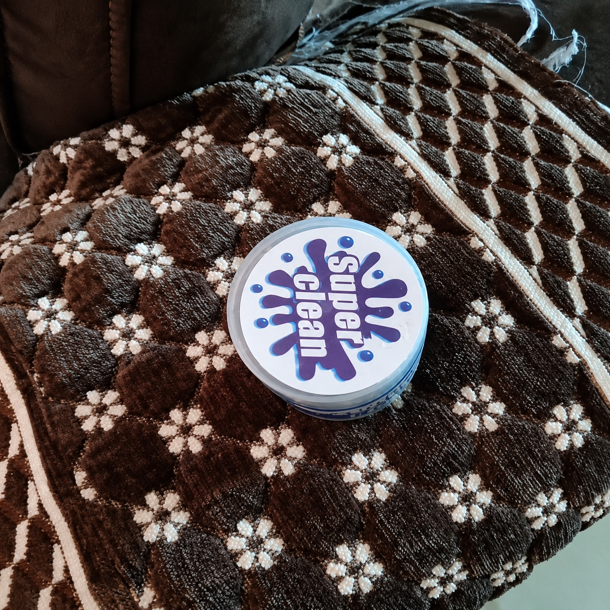 Round cleaning product with 'Super Clean' label on a textured surface